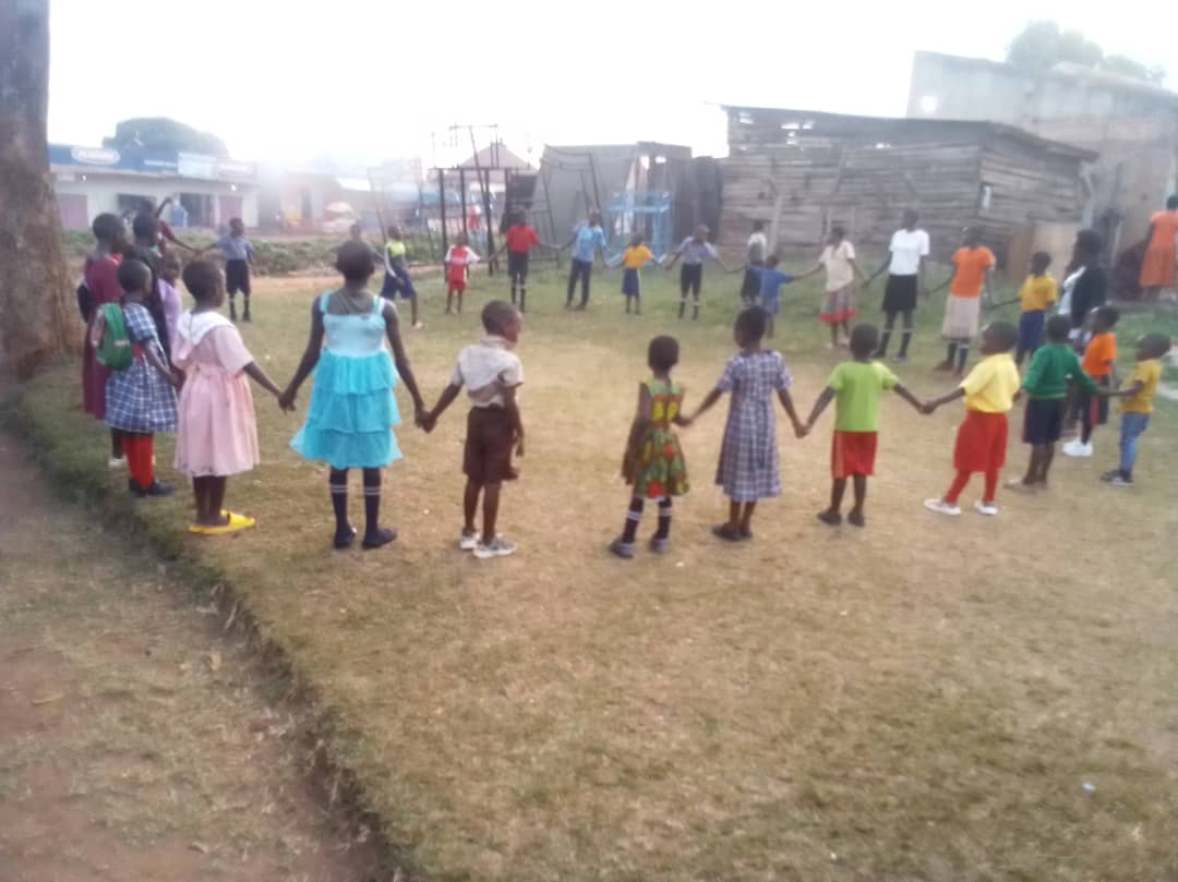 Children holding hands and playing in a circle outdoors