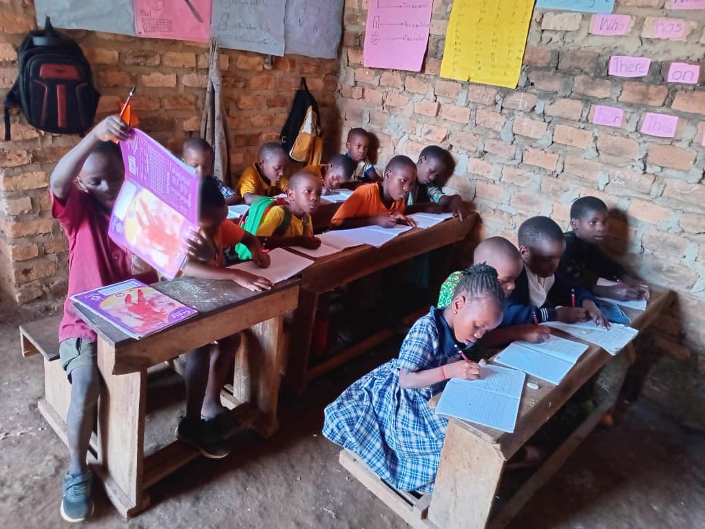 Children studying at wooden desks in a brick classroom
